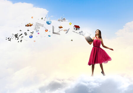 Young woman in red dress with book in handの写真素材