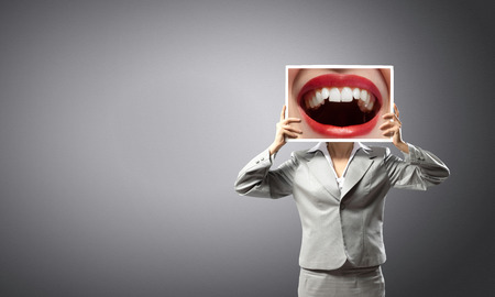 Unrecognizable businesswoman holding big photo with lipsの写真素材