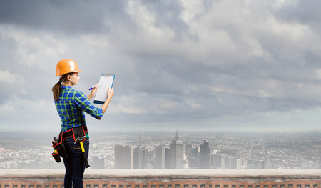 Young woman builder with folder in handの写真素材