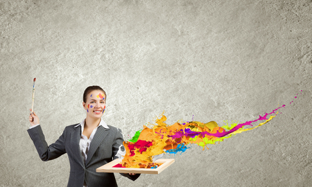 Young attractive woman in suit with paint brush in handの写真素材