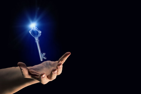 Close up of human hand holding golden keyの写真素材