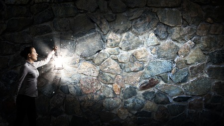 Young pretty businesswoman with lantern in darknessの写真素材