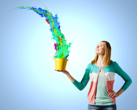 Young woman in casual holding yellow bucket with splashesの写真素材