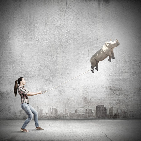 Young woman holding flying rhino on rope