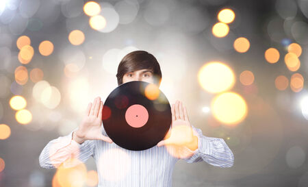 Young handsome man with disco plate in handsの写真素材