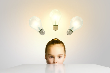 Little cute school girl and electric bulbの写真素材