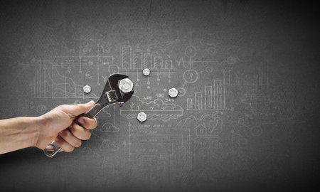 Close up of hand spinning nut with wrenchの写真素材