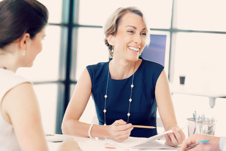 Happy business woman talking to her colleguesctationsの写真素材