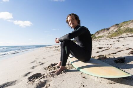 A surfer with his surfboard at the beachの写真素材