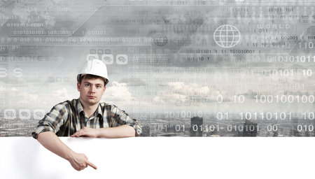 Young builder man with white blank banner. Place for text