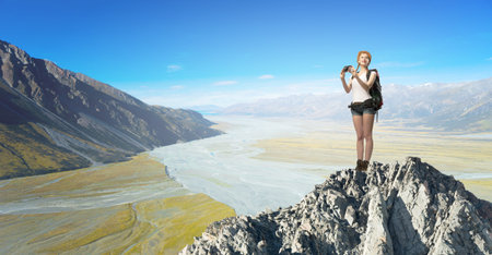 Young pretty girl tourist with backpack on back taking photos