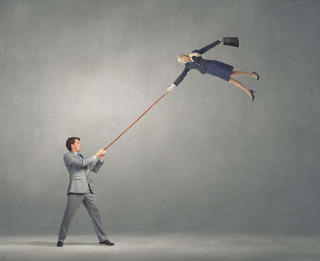 Businessman holding on lead young colleague businesswomanの写真素材
