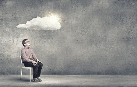 Young funny teenager guy sitting in chairの写真素材
