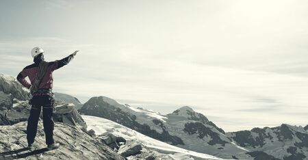 Mountaineer at peak of mountain enjoying natural landscapeの写真素材