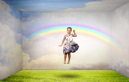 Little cute cheerful girl in room jumping highの写真素材