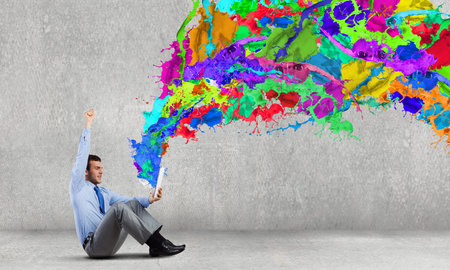 Young man sitting on floor and using tablet pcの写真素材