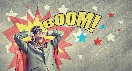 Young man in hero costume closing ears with palmsの写真素材