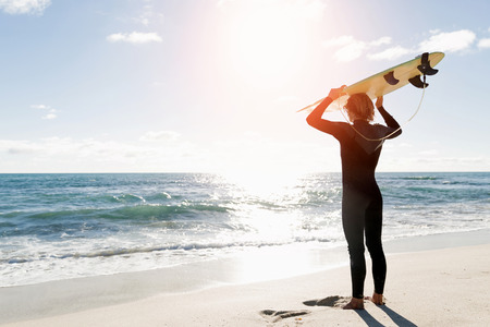 A surfer with his surfboard at the beachの写真素材