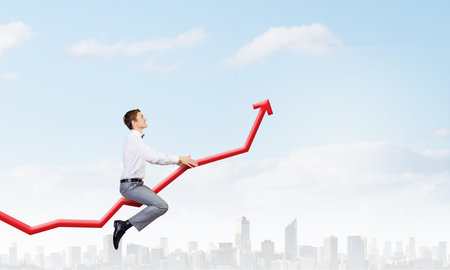 Young businessman riding graph arrow going upの写真素材