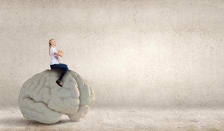 Young girl sitting on big human brain