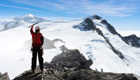 Mountaineer at peak of mountain enjoying natural landscapeの写真素材