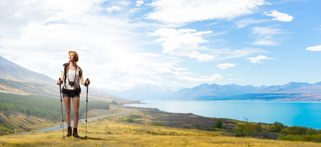 Young pretty girl tourist with backpack on back hiking at summerの写真素材