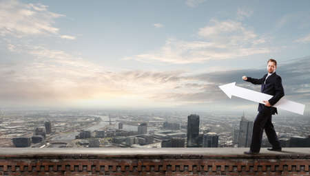 Businessman in suit with white blank arrow in handsの写真素材