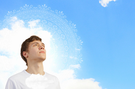 Young handsome smiling guy against sky backgroundの写真素材