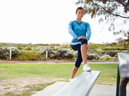 Sporty young woman stretching in the park