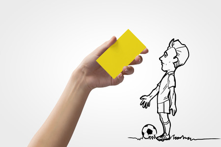 Caricature of football player and human hand showing yellow cardの写真素材