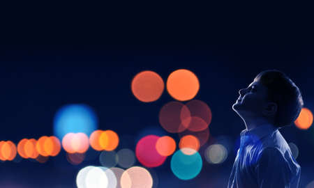 Cute boy of school age against bokeh backgroundの写真素材