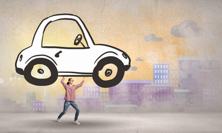 Young girl lifting drawn car above her headの写真素材