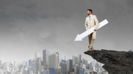 Businessman in suit holding white blank arrow in handsの写真素材