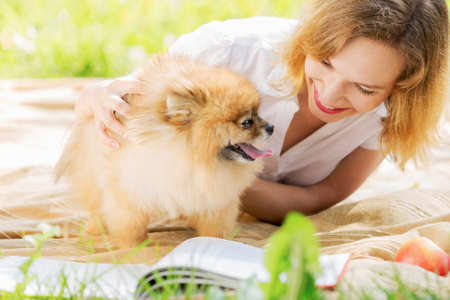 Young pretty girl in summer park with cute dogの写真素材