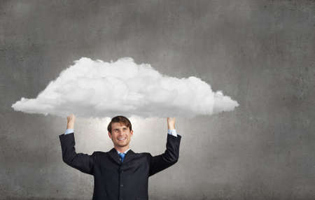 Young businessman holding media cloud above headの写真素材