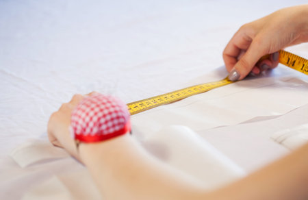 close up of dressmaker at work making patterns of fabric