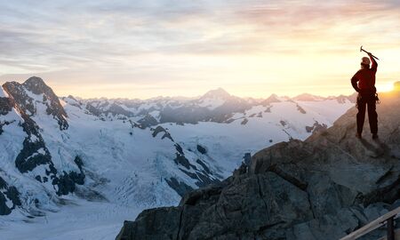 Mountaineer at peak of mountain enjoying natural landscapeの写真素材
