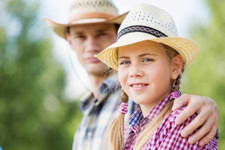 Father and daughter sitting on bridge and fishingの写真素材