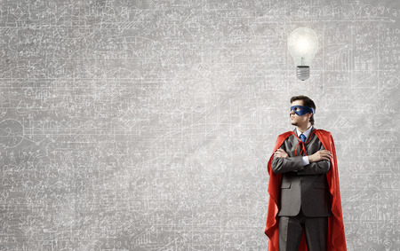 Young confident super guy in mask and capeの写真素材