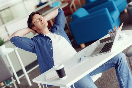 Young handsome businessman in an office having a breakの写真素材