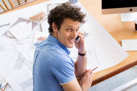 Man in casual wear with his mobile in office