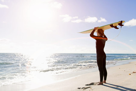 A surfer with his surfboard at the beachの写真素材