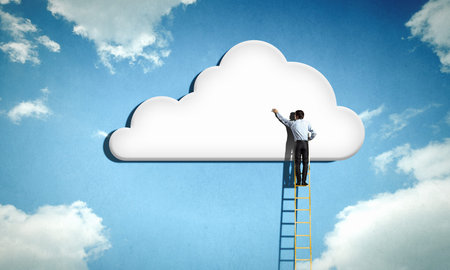 Rear view of businessman standing on ladder and reaching cloud