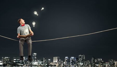Young man student sitting with book in handsの写真素材