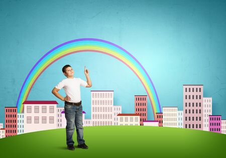 Boy of school age pointing with finger upwardsの写真素材