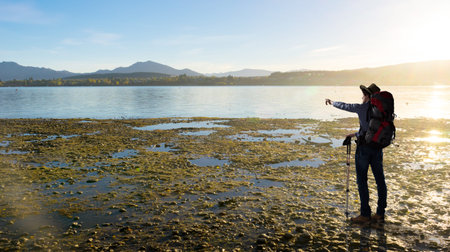 Young man hiker with backpack walking on routeの写真素材