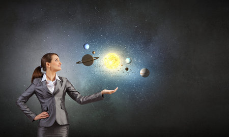 Young businesswoman and planets of space spinning around