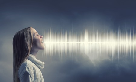 Side view of girl of school age and voice coming out of her mouthの写真素材