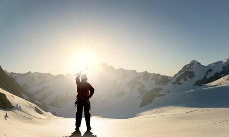 Mountaineer at peak of mountain enjoying natural landscapeの写真素材