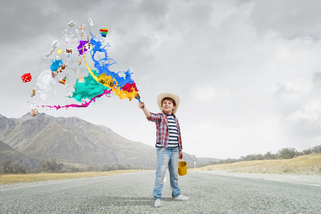 Boy of school age with yellow bucket and paint brushの写真素材